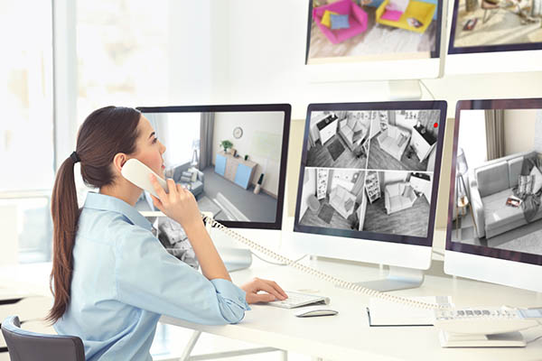 woman monitoring cctv security footage on several monitors